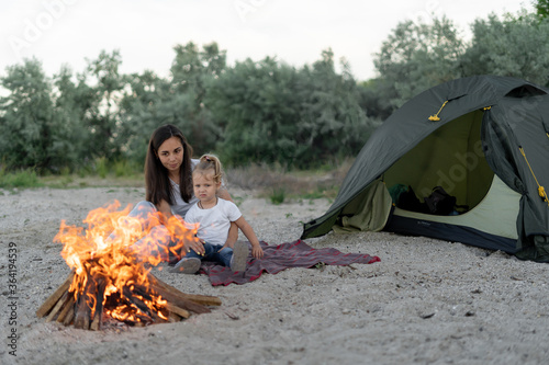 Mother and daughter enjoying fire by the tent