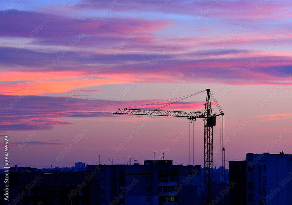 Tower crane in the evening against the sky Tower crane in the evening against the sky