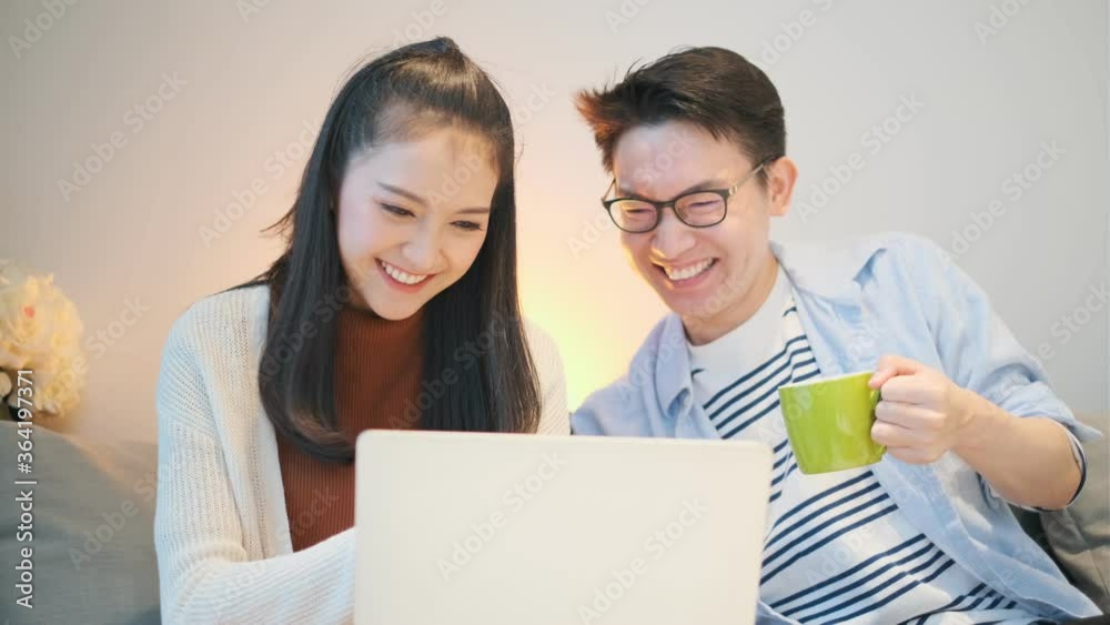 lovely asian young marry couple family enjoy leisure time with laptop enterain shopping online together with laugh and smile weekend activity on sofa home sweet home lovely asian young marry couple family enjoy leisure time with laptop enterain shopping online together with laugh and smile weekend activity on sofa home sweet home