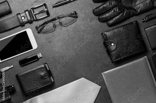 Men's accessories on a black concrete background. The concept of a successful modern man. Copy space