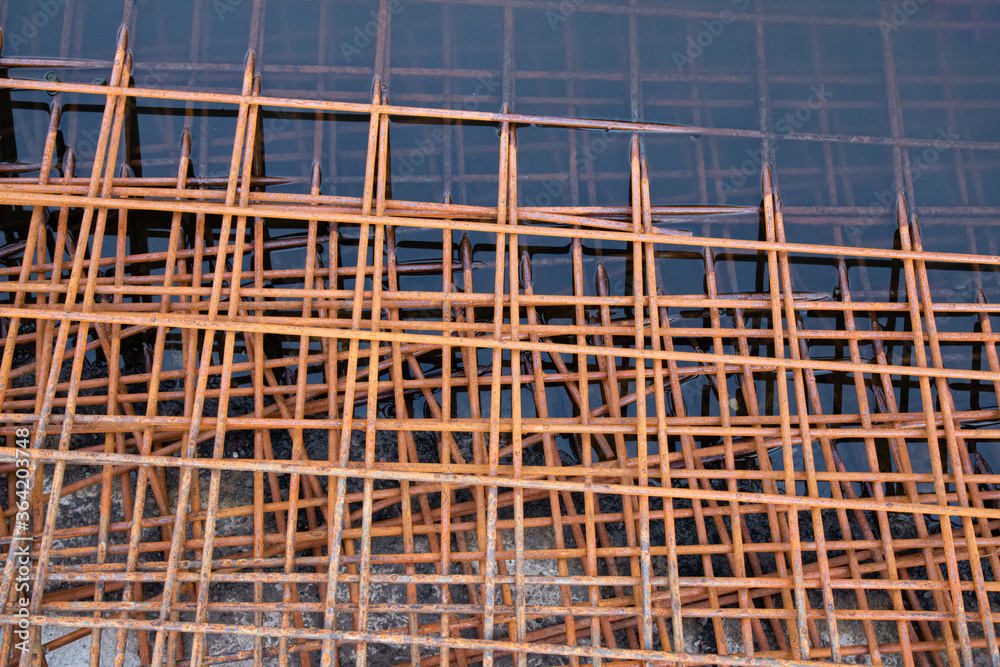 The rusty steel grid in pattern,Rusty construction metal mesh. Rusty Metal armature net for  road infrastructure  metal rebar for construction,Sites Soak in Water and Rust.