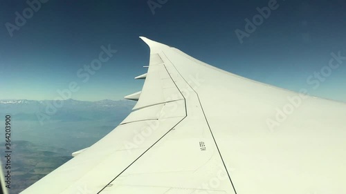 Video of the window of an airplane flying with a blue sky. Travel concept