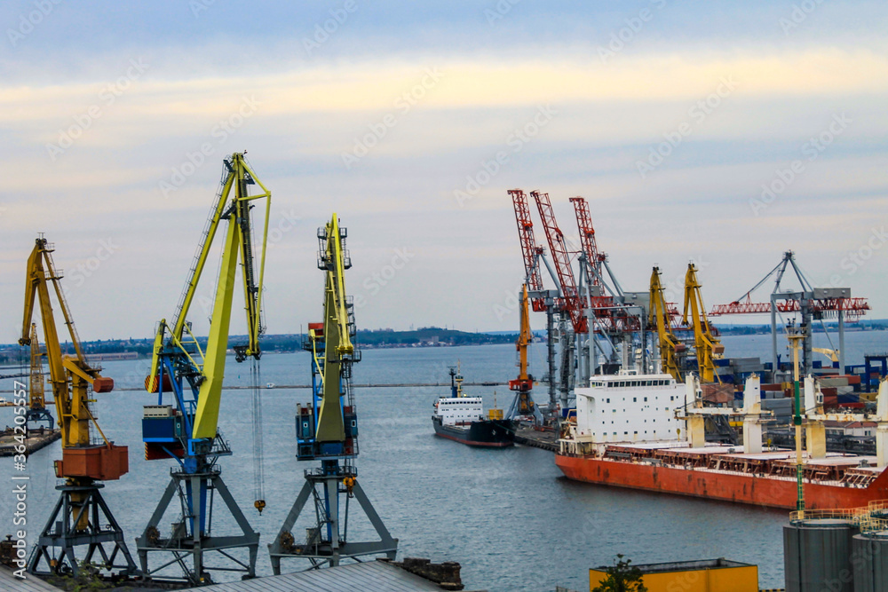Hoisting cranes and industrial ships at cargo sea port in Odessa, Ukraine