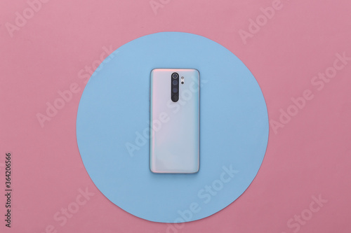 Modern smartphone back with lenses on a blue pink background. Top view