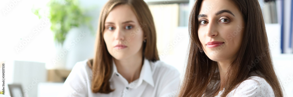 Portrait of gorgeous businesspeople sitting indoors and looking at camera with gladness. Beautiful businesswoman discussing important charts and graphs. Accounting office concept Portrait of gorgeous businesspeople sitting indoors and looking at camera with gladness. Beautiful businesswoman discussing important charts and graphs. Accounting office concept