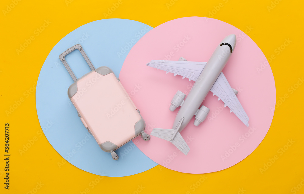 Mini travel luggage and air plane on colored background. Top view. Flat lay. Minimalism Mini travel luggage and air plane on colored background. Top view. Flat lay. Minimalism