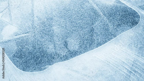 Close-up of melting ice texture. Studio shot close-up of the blue surface of cracked melting ice in time lapse.
