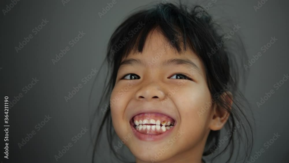 Asian girl looking at the camera and smiling in slow motion Asian girl looking at the camera and smiling in slow motion
