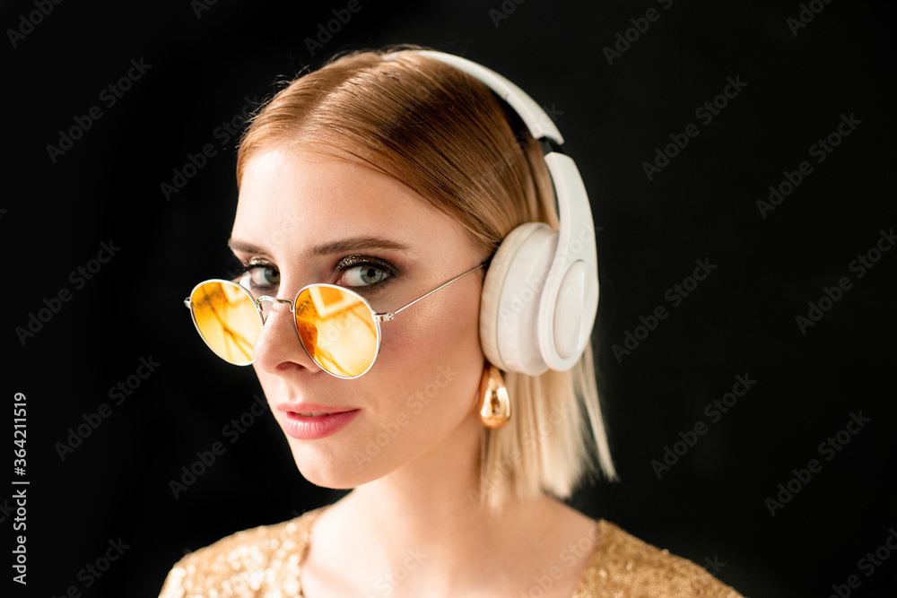 Young blond glamorous woman in white headphones and stylish sunglasses Young blond glamorous woman in white headphones and stylish sunglasses