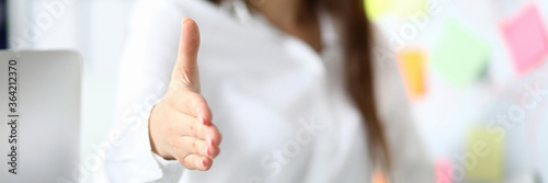 Картината върху платно Cheerful female clerk welcoming business partner by shaking hand as sign of futu