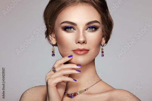 Portrait Beautiful Woman with Jewelry. Model Girl with Violet Manicure on Nails. Elegant Hairstyle. Violet Make-up Arrows. Beauty and Accessories