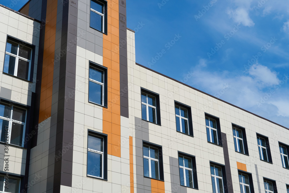 facade of a modern building on a bright Sunny day, siding and Windows, beautiful exterior of the new building facade of a modern building on a bright Sunny day, siding and Windows, beautiful exterior of the new building