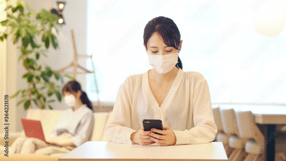マスクをしてスマホを見る女性