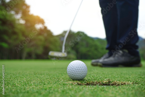 Blurred golfer playing golf in beautiful golf course in the evening golf course with sunshine in thailand.