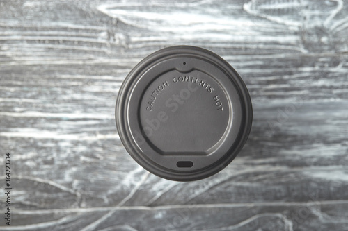 Take away plastic coffee cup cap on grey wooden background