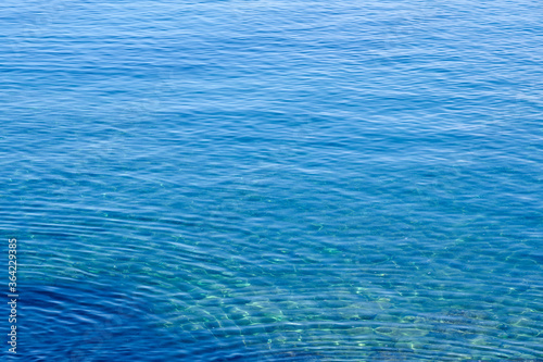 Texture of a clear transparent tropical Sea water on the coast of Crete, Greece as a natural background.