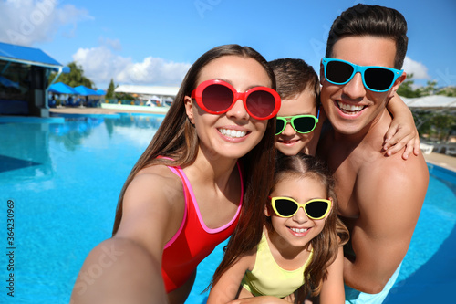 Happy family taking selfie near swimming pool. Summer vacation