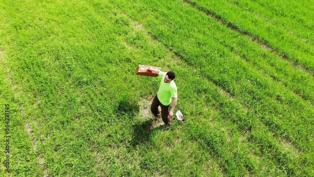 man alone men spinning in a green field, holding suitcase in a hand, funny travel concept, retro style, aerial shot from drone, top view from above, adventures, happy, creative freedom, way of life man alone men spinning in a green field, holding suitcase in a hand, funny travel concept, retro style, aerial shot from drone, top view from above, adventures, happy, creative freedom, way of life
