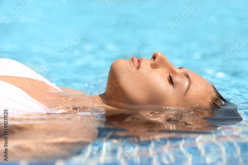Beautiful young woman relaxing in outdoor swimming pool © New Africa