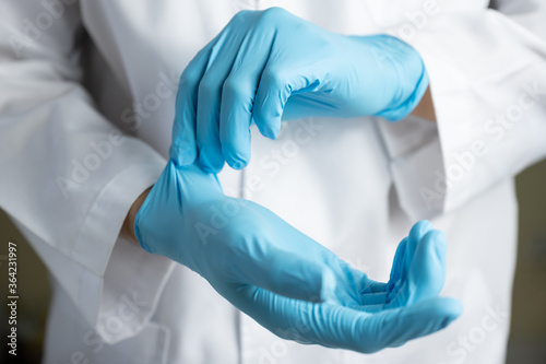 Doctor wearing blue nitrile gloves photo