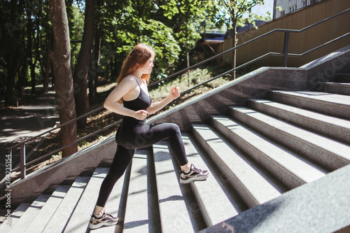 Street fitness, cardio workout, sport in the city. Young fit woman exercising on the stairs. Endurance and healthy lifestyle