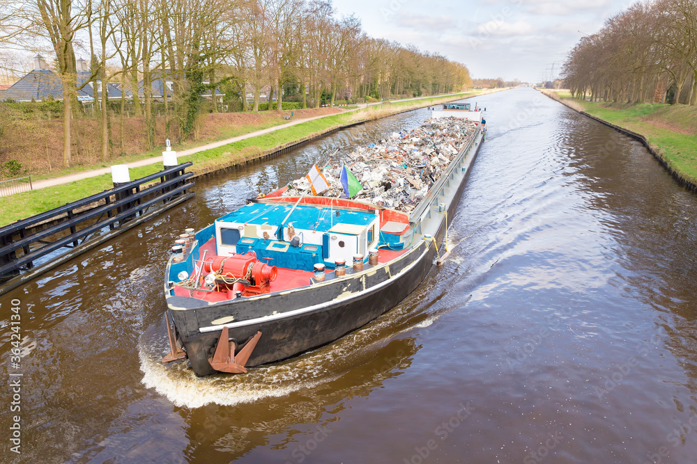 Cargo ship sails with recyclable metal on river