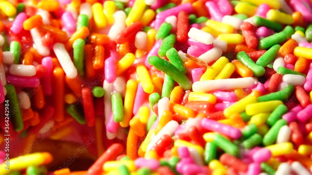4K Delicious sweet donut rotating on a plate. Top view. Bright and colorful sprinkled donut close-up macro shot spinning on a black background. 4K Delicious sweet donut rotating on a plate. Top view. Bright and colorful sprinkled donut close-up macro shot spinning on a black background.