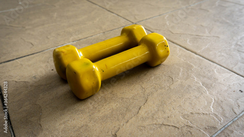 Pairs of 1 kilogram yellow mini dumbbells on the floor.