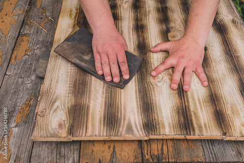 Foto sandpaper wood treatment/type of male hands processing sandpaper wood