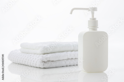 白いタオルと消毒液が入ったポンプ/除菌イメージ