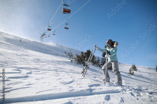 A woman posing with ski in mountain ski resort in winter season,sunny day