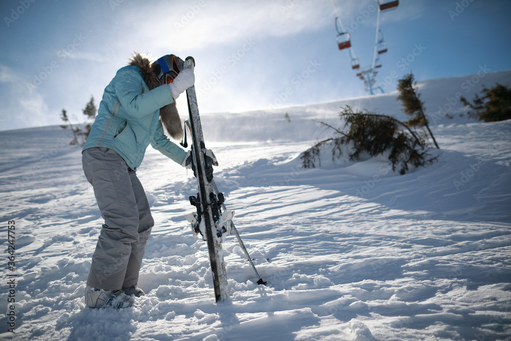 A woman posing with ski in mountain ski resort in  winter season,sunny day