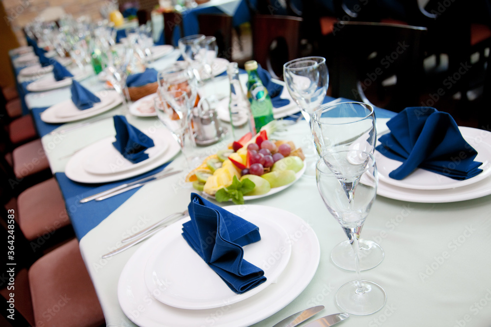 Fototapeta premium Restaurant table with empty wineglasses and plates for banquet or wedding dinner