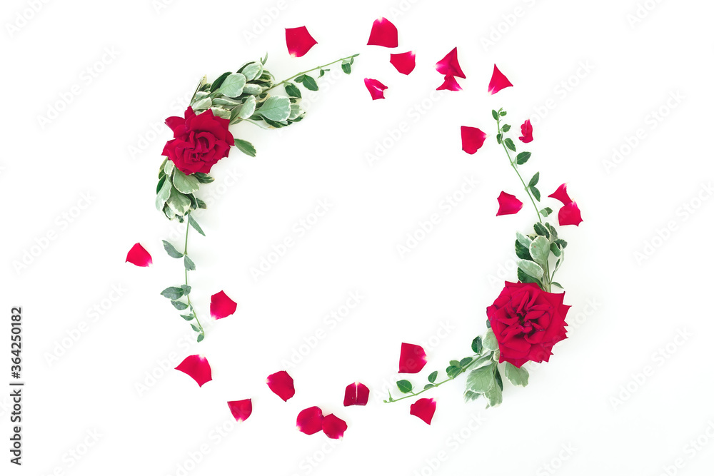 Round frame made of red roses flowers and green leaves on white background. Flat lay