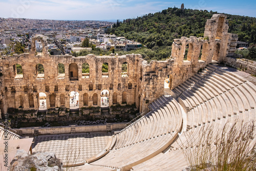 Panoramic view of Odeon of Herodes Atticus stone Roman theater, Herodeion or Herodion, at slope of Acropolis hill with metropolitan Athens, Greece in background