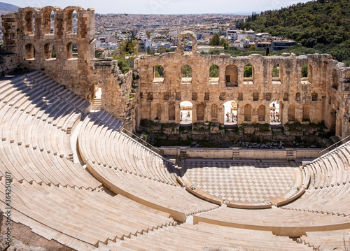 Panoramic view of Odeon of Herodes Atticus stone Roman theater, Herodeion or Herodion, at slope of Acropolis hill with metropolitan Athens, Greece in background photo