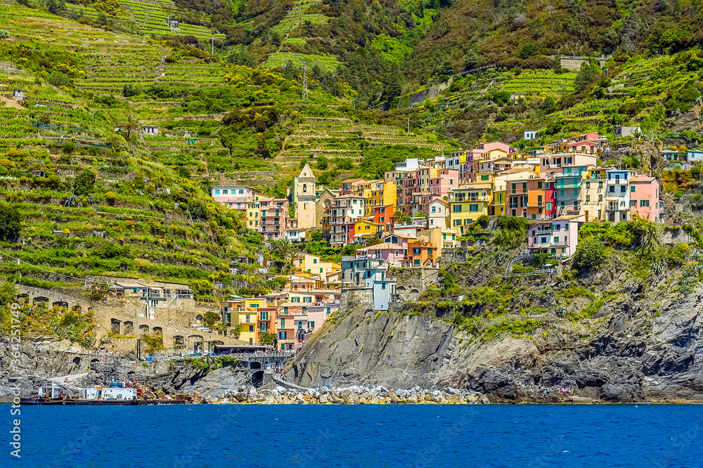 A view across the breakwater towards the Cinque Terre village of Manarola, Italy in the summertime