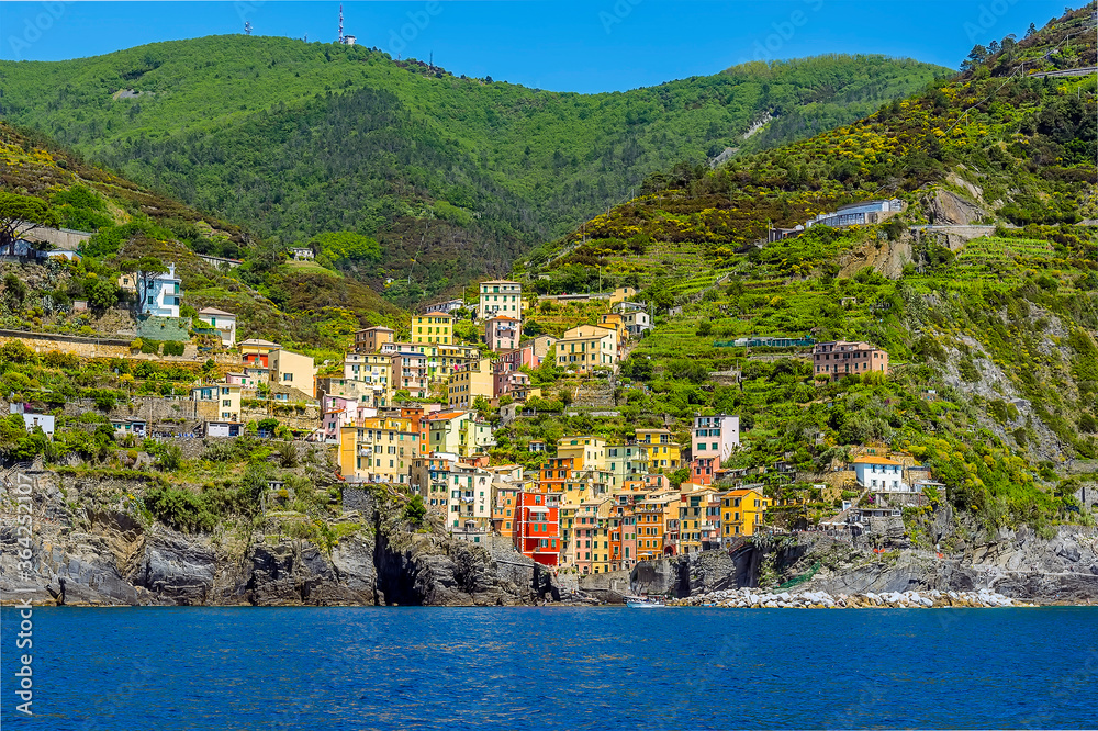 A view from the sea towards the hillside and Cinque Terre village of Riomaggiore, Italy in the summertime