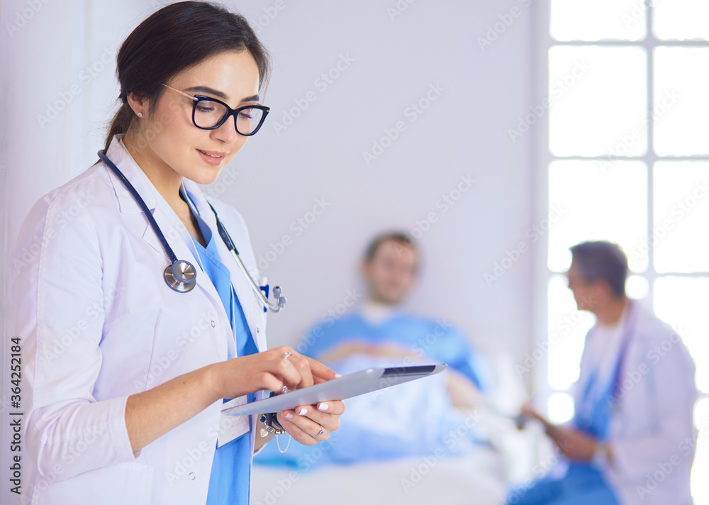 Female doctor using tablet computer in hospital lobby Female doctor using tablet computer in hospital lobby
