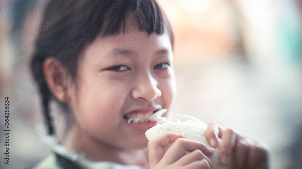 Asian child girl eating some bread with smile and happy Asian child girl eating some bread with smile and happy