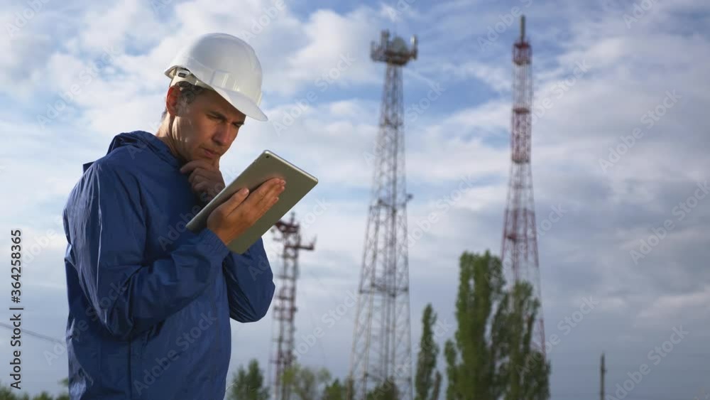 A telecommunications engineer working on a digital tablet records data for maintenance of the telecommunications network. Design, repair and installation of satellite and telecommunications networks. A telecommunications engineer working on a digital tablet records data for maintenance of the telecommunications network. Design, repair and installation of satellite and telecommunications networks.
