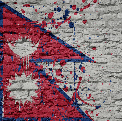 painted big national flag of nepal on a massive old brick wall