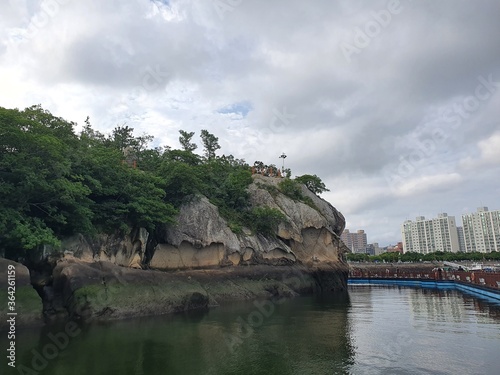 Mokpo-si, South Korea - 5th July 2020 : Scenery of Gatbawi, designated as Korea Natural Monument no. 500, is the rock shaped with two men standing with satgat