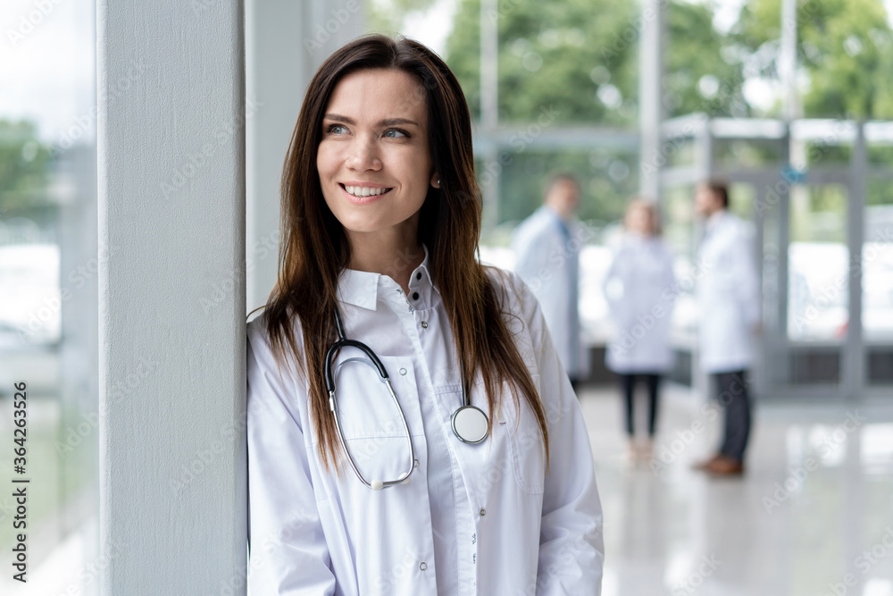 Portrait of young woman doctor with white coat standing in hospital. Portrait of young woman doctor with white coat standing in hospital.
