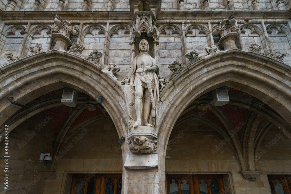 Details of the medieval architecture in Brussels. Stone building facade. Statue of a man warrior with a sword. Heritage and touristic concepts. Photography in summer day