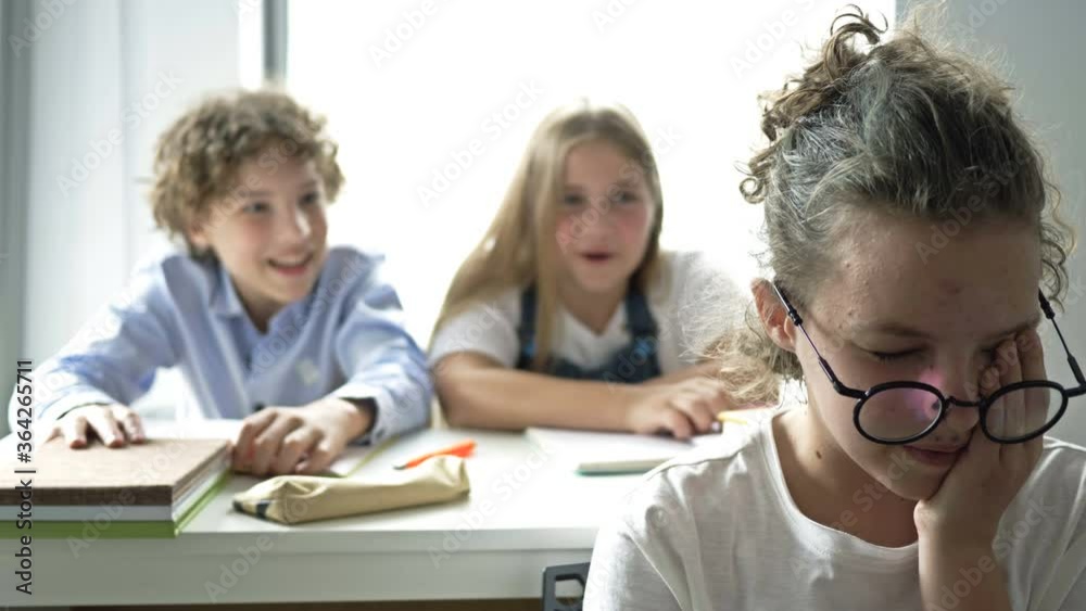 Two teens scoff at their defenseless classmate. Child cruelty. School bullying.