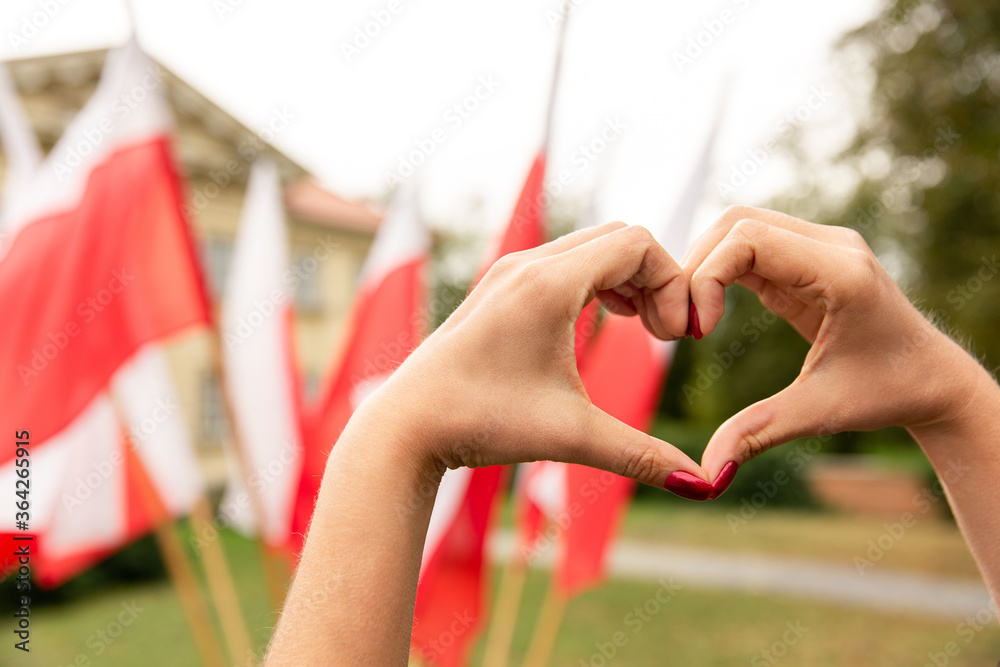 Gesture heart on the background of the flag of Poland - obrazy, fototapety, plakaty 
