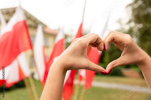 Gesture heart on the background of the flag of Poland