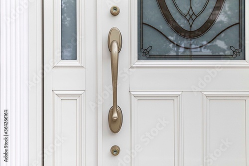 Close - up Brass door handle and white wooden door