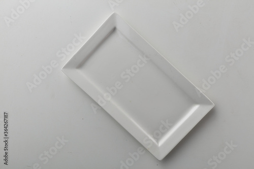 Top view shot of a rectangular white plate on white background.